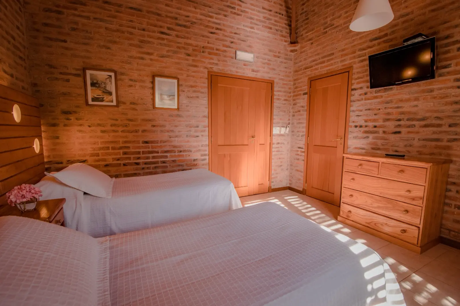 Habitación de la cabaña con dos camas y salida al bosque